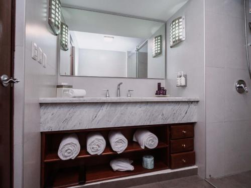 a bathroom with a sink and a mirror and towels at HS HOTSSON Hotel Tampico in Tampico