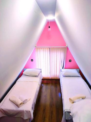 Drei Betten in einem Zimmer mit rosa Decke in der Unterkunft Lenkeran Aframe in Länkäran