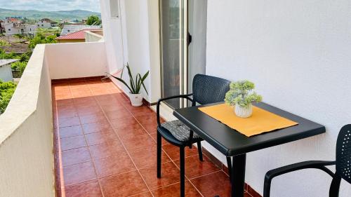 un piccolo tavolo nero e delle sedie su un balcone di Hills View a Divjakë