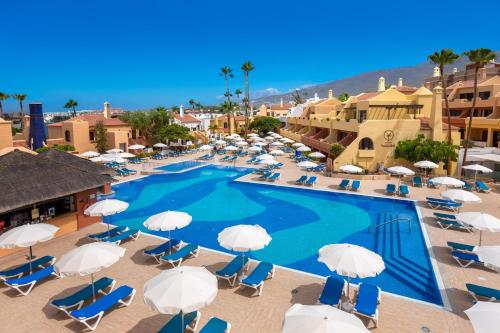 an overhead view of a swimming pool with chairs and umbrellas at Tagoro Family & Fun Costa Adeje in Adeje