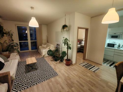 a living room with potted plants on the floor at Boho style apartment with garage and large terrace in Bratislava