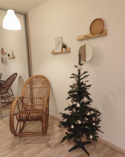 a christmas tree in a living room with a chair at Boho style apartment with garage and large terrace in Bratislava