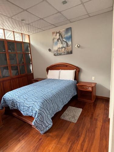 a bedroom with a bed with a horse picture on the wall at Casa La Ronda in Quito