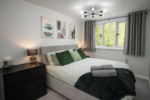 a bedroom with a bed and a dresser and a window at Stylish 4 Bed House, Free Parking, Close to M4 Newport in Newport