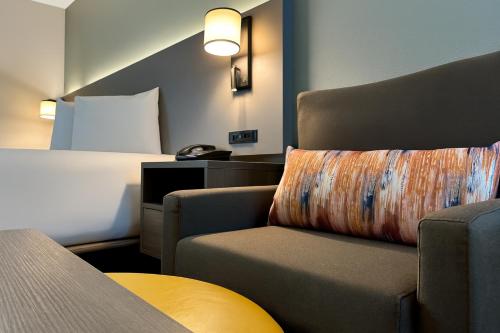 a hotel room with a chair and a bed at Dakota Inn in Minot
