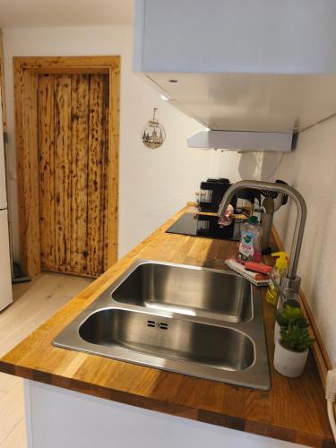a stainless steel sink in a kitchen with a wooden counter at Große Auszeit Eifel mit Sauna, Kamin und Terrasse in Nettersheim