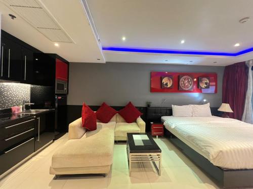 a bedroom with a bed and a couch and a table at Patong Condo Tub, Roof Pool & 2-min to Beach in Patong Beach