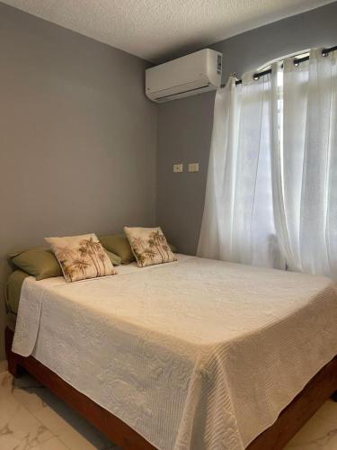 a bedroom with a large bed with a window at Apartamento Piro 1 - 4 pax - a 5 Min De La Playa in Las Galeras