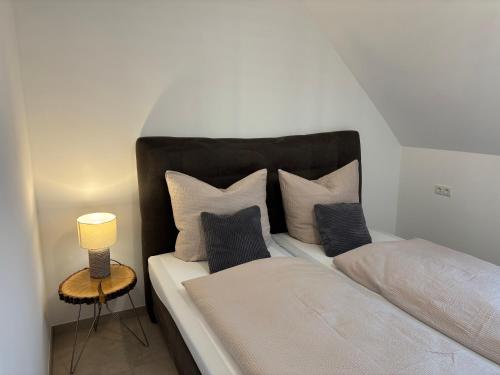 a bedroom with a bed with pillows and a lamp at Kiefer in Nortrup