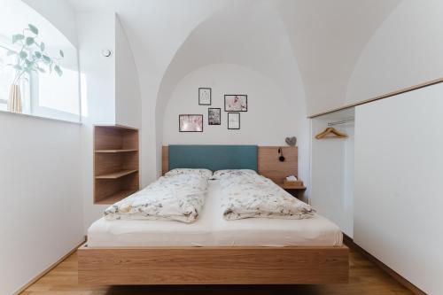 a bedroom with a bed with a wooden headboard at Gut Pecketsberg in Oepping