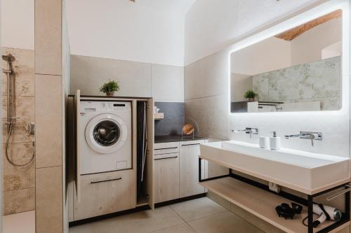 a bathroom with a washing machine and a sink at Gut Pecketsberg in Oepping