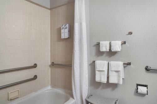 a bathroom with a tub and a shower with towels at Red Roof Inn Queensbury in Queensbury