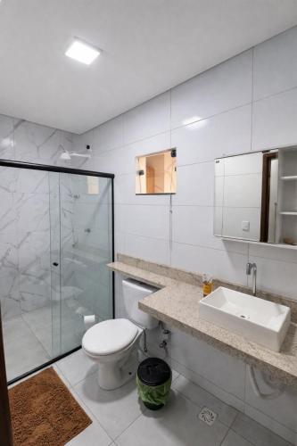 a bathroom with a toilet and a sink and a shower at Casa 3 Quartos Ar Condicionado , Area de Churrasco in Petrolina