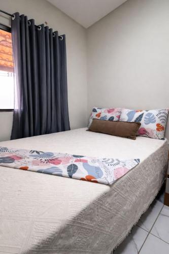 a bed in a bedroom with black curtains at Casa 3 Quartos Ar Condicionado , Area de Churrasco in Petrolina