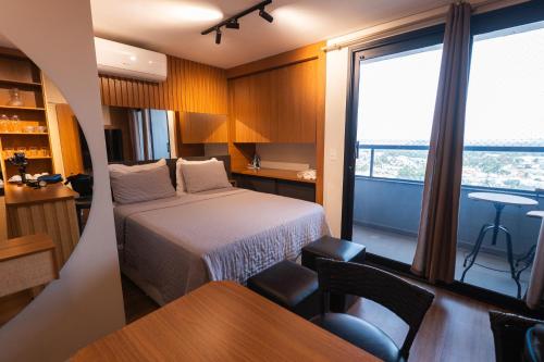 a hotel room with a bed and a window at Studio Prime Cuiaba 1709 in Cuiabá