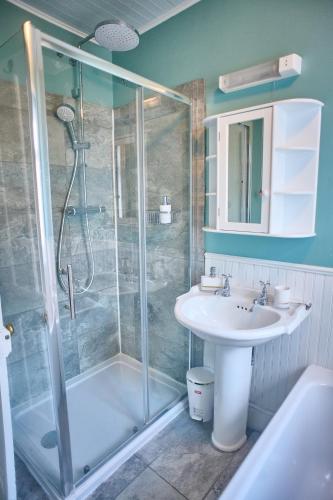 a bathroom with a shower and a sink at Large family home, sea view, hot tub, beach 5 min walk, dog friendly in Gorleston-on-Sea