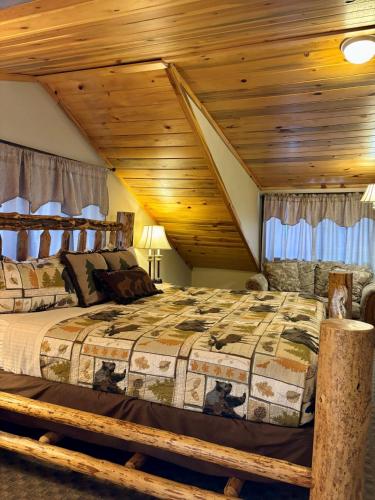 a bedroom with a bed with a wooden ceiling at Riverfront Motel & Cabins in Thompson Falls