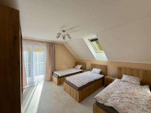 a room with two beds and a window at Między Wzgórzami Korbielów in Korbielów