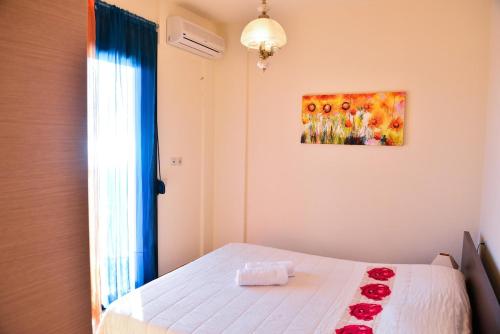 a bedroom with a bed with red roses on it at Villa Eli Keratokampos in Kastrí