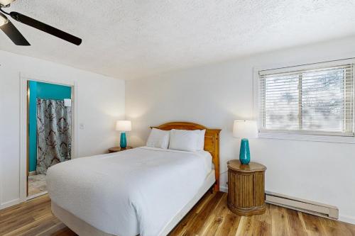 a white bedroom with a bed and a window at Live Laugh Lake - A in Rushville