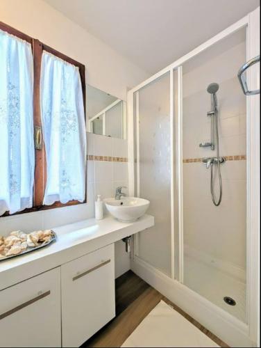 a white bathroom with a sink and a shower at Rooftop Carcente in San Siro