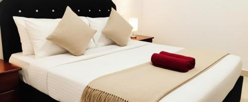 a bedroom with a bed with a red suitcase on it at Yala Eagle Nest & Safari in Tissamaharama