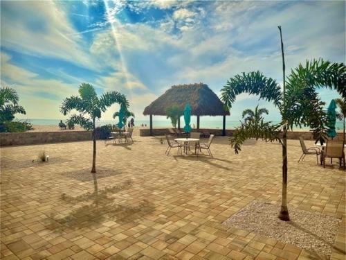 a patio with chairs and umbrellas on the beach at A Beach Retreat on Casey Key in Venice