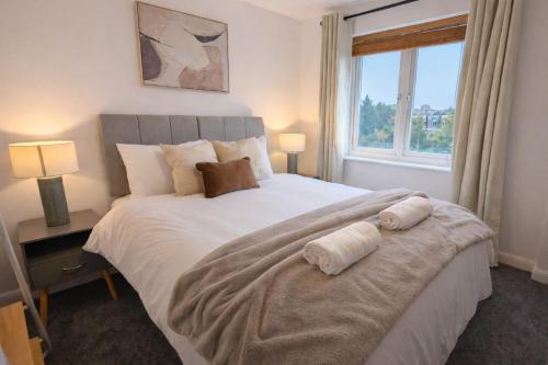 a bedroom with a large bed with two towels on it at 36 Handley's Elite Apartment 2Bed Flat CityCenter in Hemel Hempstead