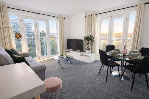a living room with a tv and a table and chairs at 36 Handley's Elite Apartment 2Bed Flat CityCenter in Hemel Hempstead