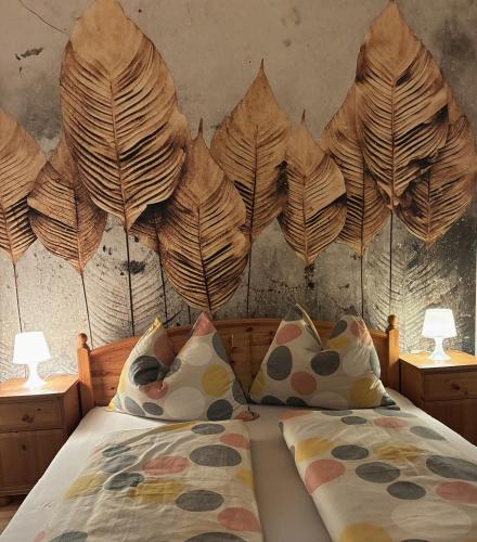 a bedroom with a bed with a leaf headboard at Haus Schloßbergblick in Leutschach