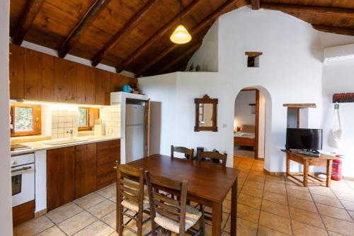 a kitchen with a wooden table and a dining room at Tzokeika Traditional Settlement in Riglia