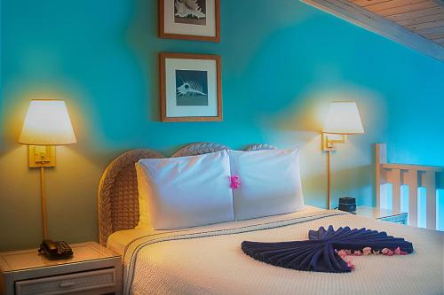 a bedroom with a bed with two lamps and a bedspread at Trade Winds Hotel Antigua in Dickenson Bay