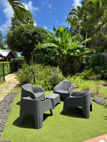 a group of chairs sitting on the grass at Golden Vibes in Petit-Bourg