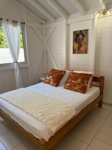 a large bed in a bedroom with a window at Golden Vibes in Petit-Bourg