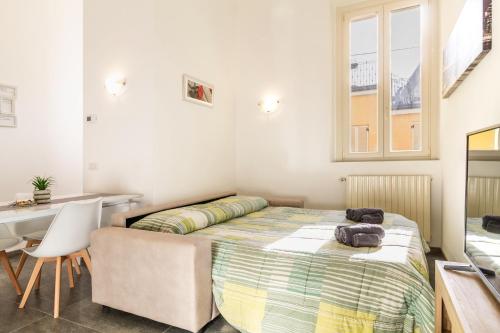 a bedroom with a bed and a desk and a table at Malpensa sweet home in Busto Arsizio