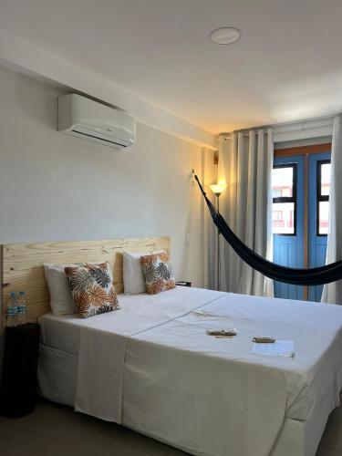 a bedroom with a large white bed in a room at Pousada VilaZinha in Vila Velha