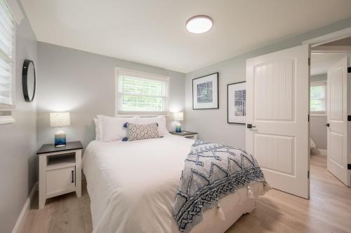 a bedroom with a white bed and a white door at Modern Home 2 Miles to Virginia Tech in Blacksburg