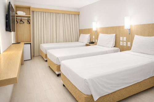 a hotel room with two beds and a television at Amapá Hotel in Macapá