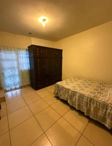 a bedroom with a bed and a dresser at Depa del descanso in Mexico City
