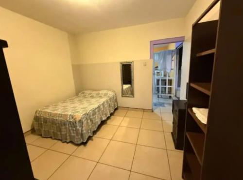a bedroom with a bed and a tiled floor at Depa del descanso in Mexico City