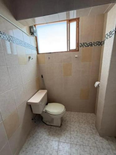 a bathroom with a toilet and a window at Depa del descanso in Mexico City