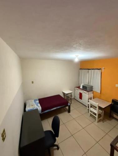 a room with a bed and a table and a desk at Depa del descanso in Mexico City