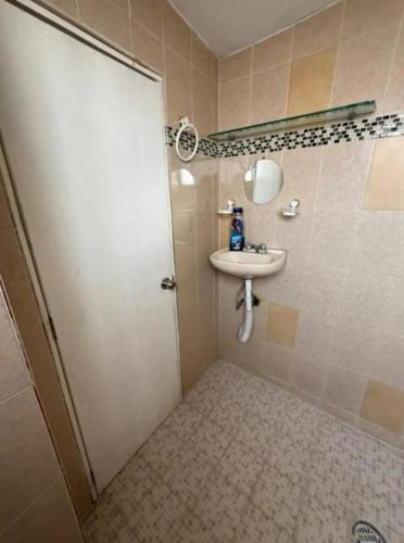 a bathroom with a sink and a shower door at Depa del descanso in Mexico City