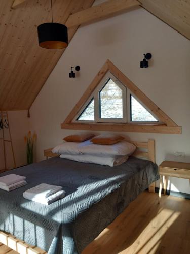 a bedroom with a bed with a large window at LoftLove roztocze domek in Jędrzejówka