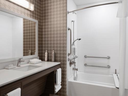 a bathroom with a sink and a tub and a shower at Tru By Hilton Norwalk Des Moines in Norwalk