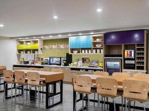 a kitchen with a table and chairs in a restaurant at Tru By Hilton Norwalk Des Moines in Norwalk