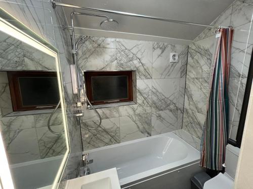 a bathroom with a white tub and a shower at Minstead Houses - 5 Bedroom Contractor House Sleeps 9 Parking for 2 Vans Near Bromford Duddeston Fort Dunlop Star City HS2 in Birmingham
