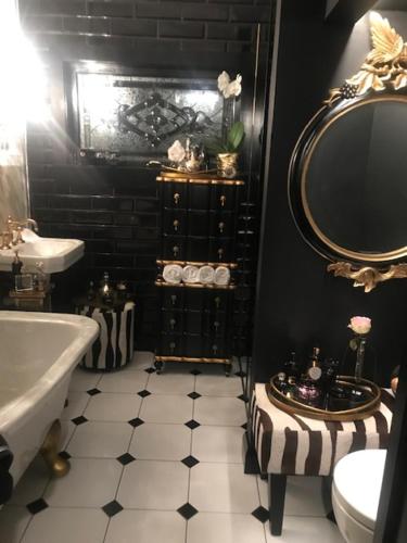 a black and white bathroom with a sink and a mirror at La Belle Maison in Tauranga