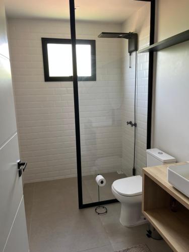 a bathroom with a toilet and a sink and a window at Le Chateau Lavande in Balsa Nova