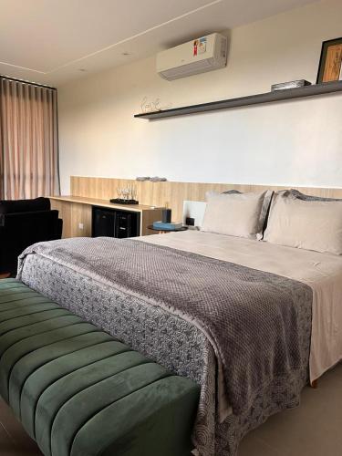 a bedroom with a large bed with a green ottoman at Le Chateau Lavande in Balsa Nova